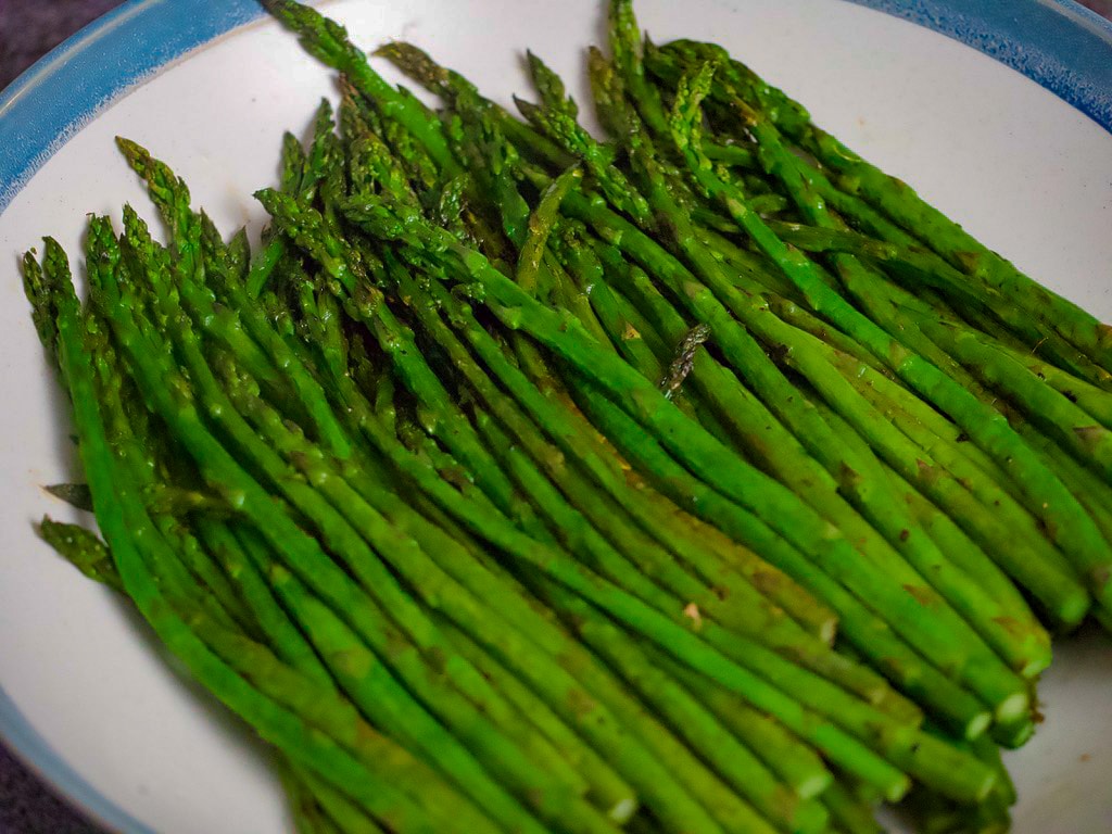 Roasted asparagus in blue and white serving plate