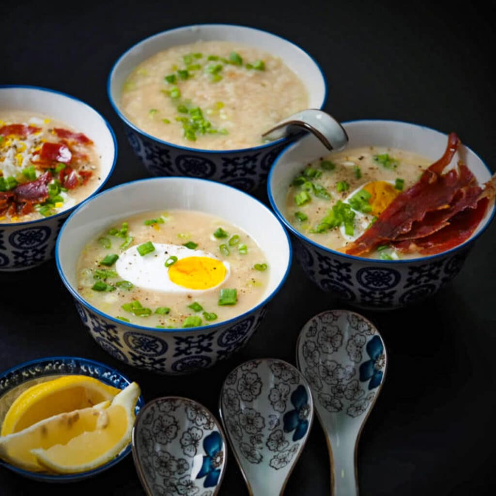 4 bowls of gingery rice porridge top with crispy prosciutto and hard boiled eggs