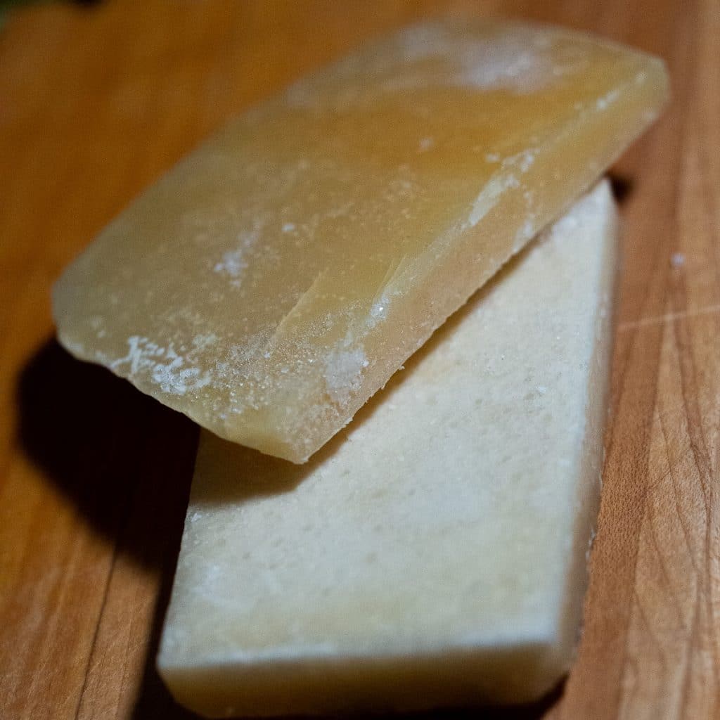 Two pieces of parmesan rind on a wooden board