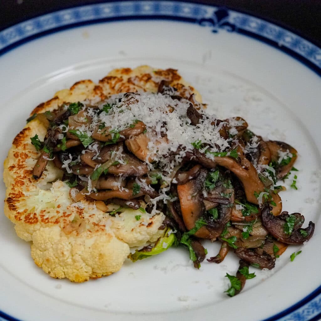 Seared cauliflower steak and top with sauteed thinly sliced mushroom. sprinkle with grated parmesan cheese and chopped parsley.