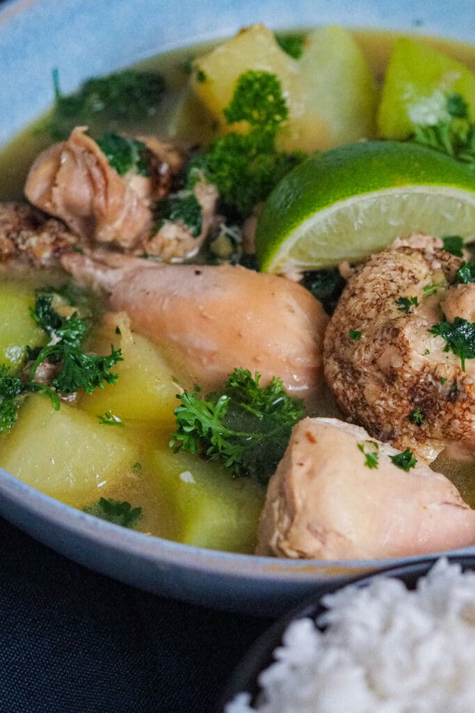 Chicken tinola- chicken pieces, chunky slices of green papaya and chayote garnished with chopped parsley and a slice of lime.