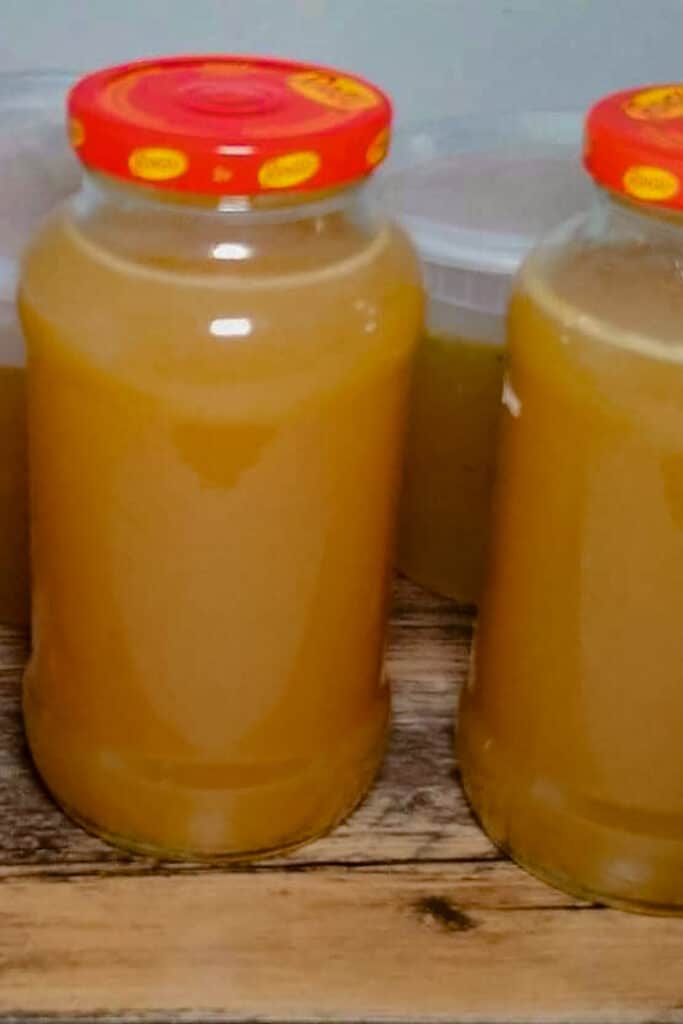 Chicken stock in two glass container and in plastic container behind