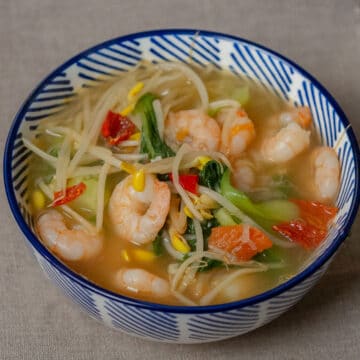 3 lime-hot and sour shrimp soup in a white and blue bowl