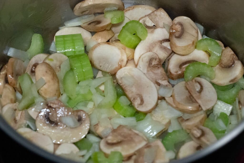 Sauteed onions, chopped celery and thinly sliced mushroom in a sauce pan.