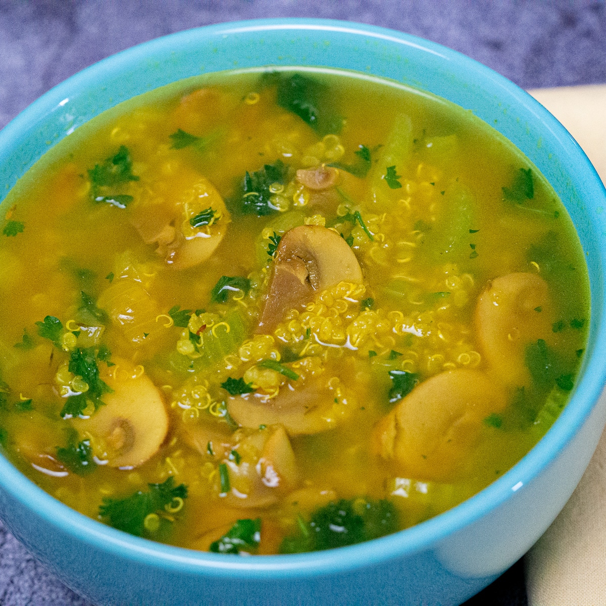 Quinoa and mushroom soup with celery, turmeric and chopped parsley