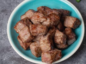 Seared beef cubes in a blue plate