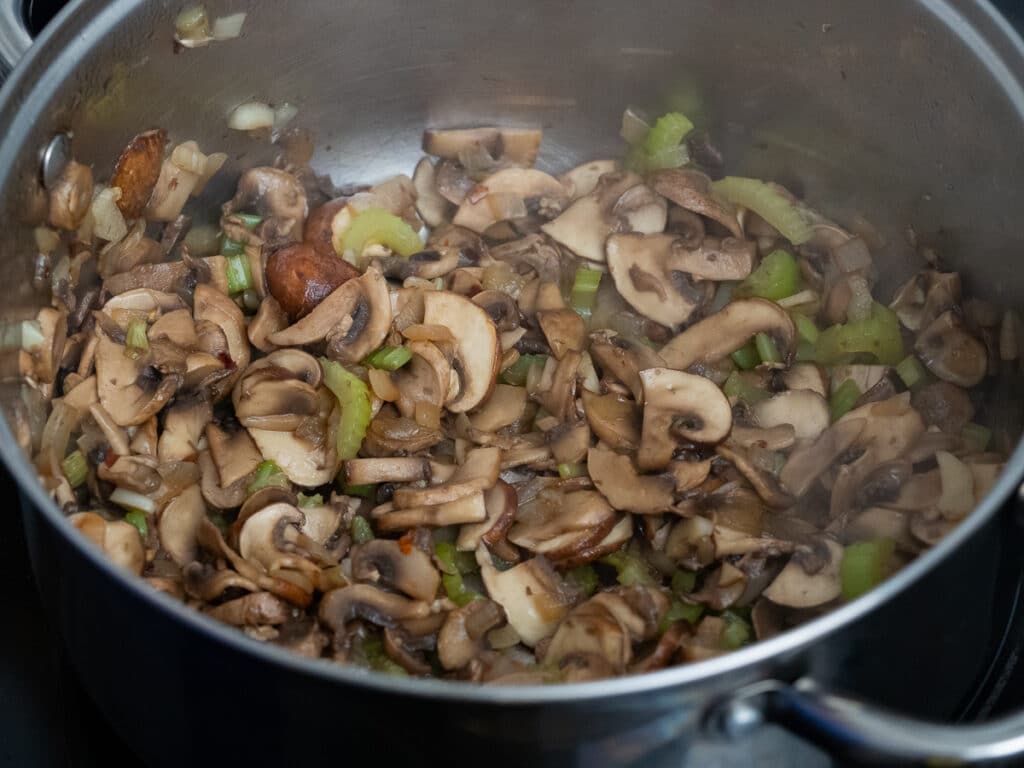 caramelized mushroom with celery and onions in a sauce pan.