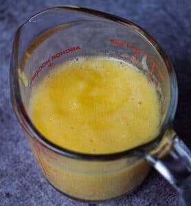 Pureed pineapple vinaigrette in a measuring glass