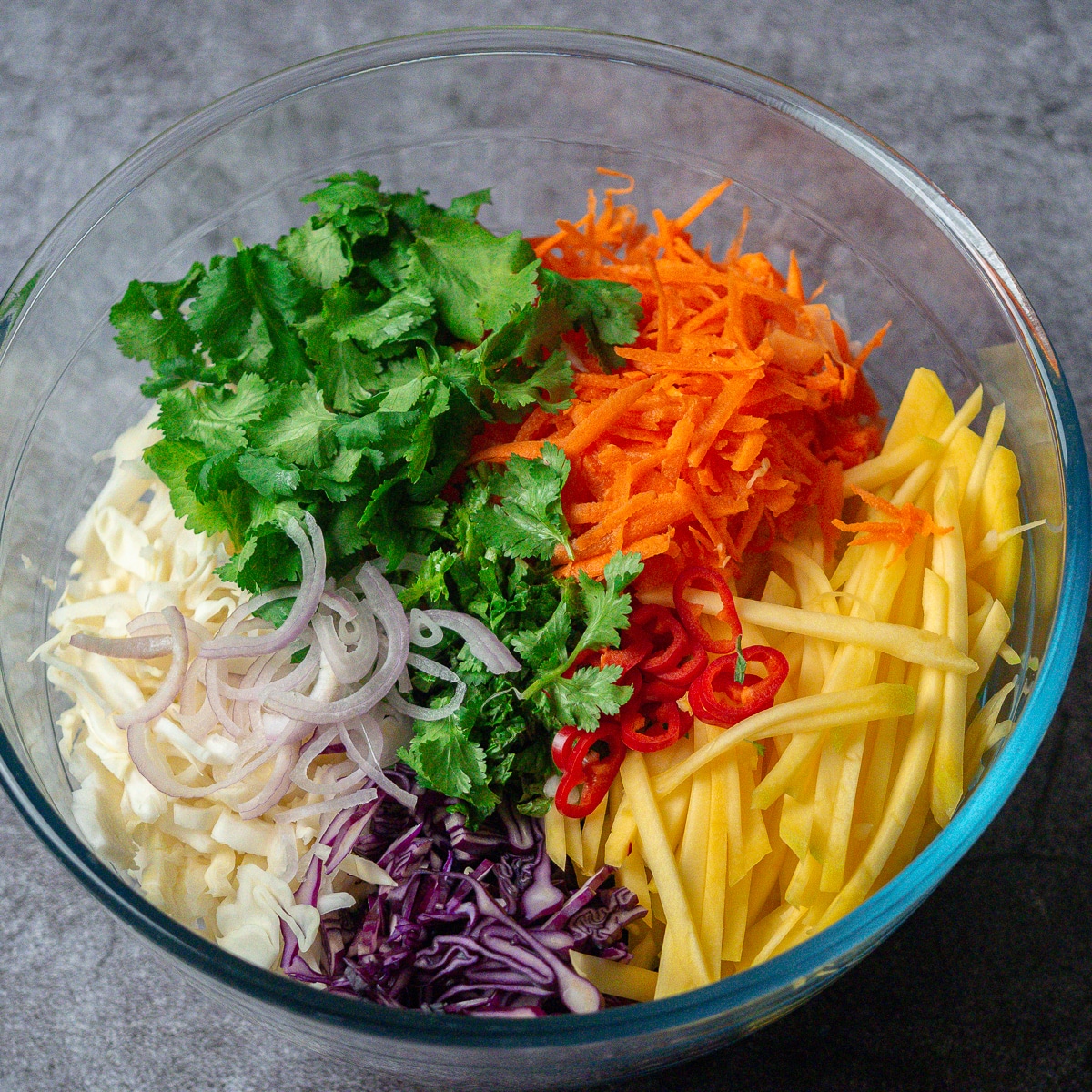 tropical coleslaw in a clear large serving bowl