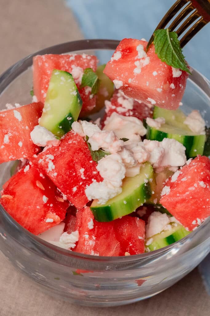 watermelon and cucumber salad in a clear glass bowl.